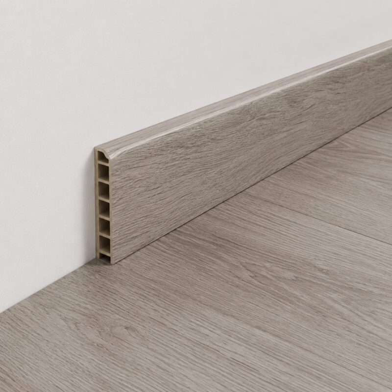 Rodapie decorativo SKIRTING-90 instalado sobre suelo efecto madera